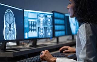 Medical professional looking at scans on a computer.