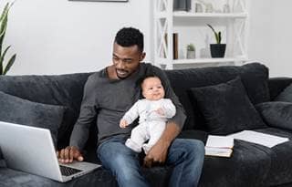 Parent and their baby sitting on the couch.