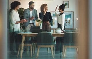 Business professionals smiling and celebrating an award.