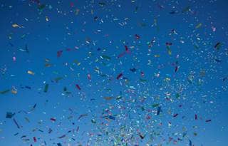 Colorful confetti on a dark blue background.