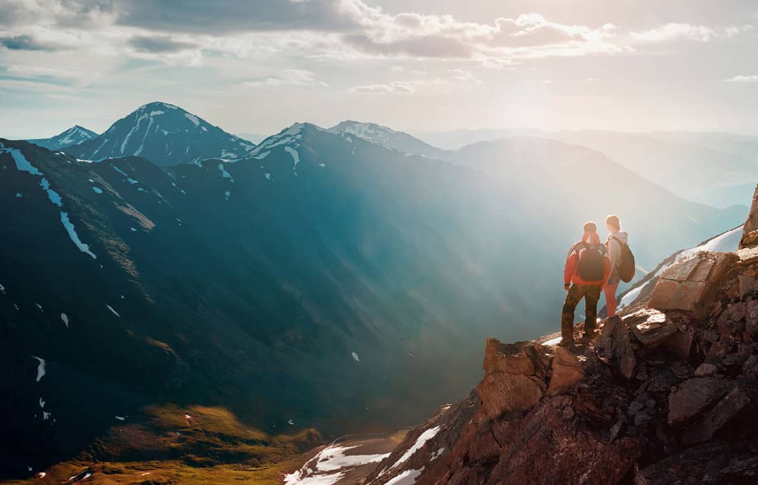 Two hikers looking out at a mountaintop.