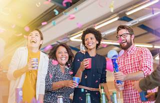 Business professionals celebrating with confetti at work.