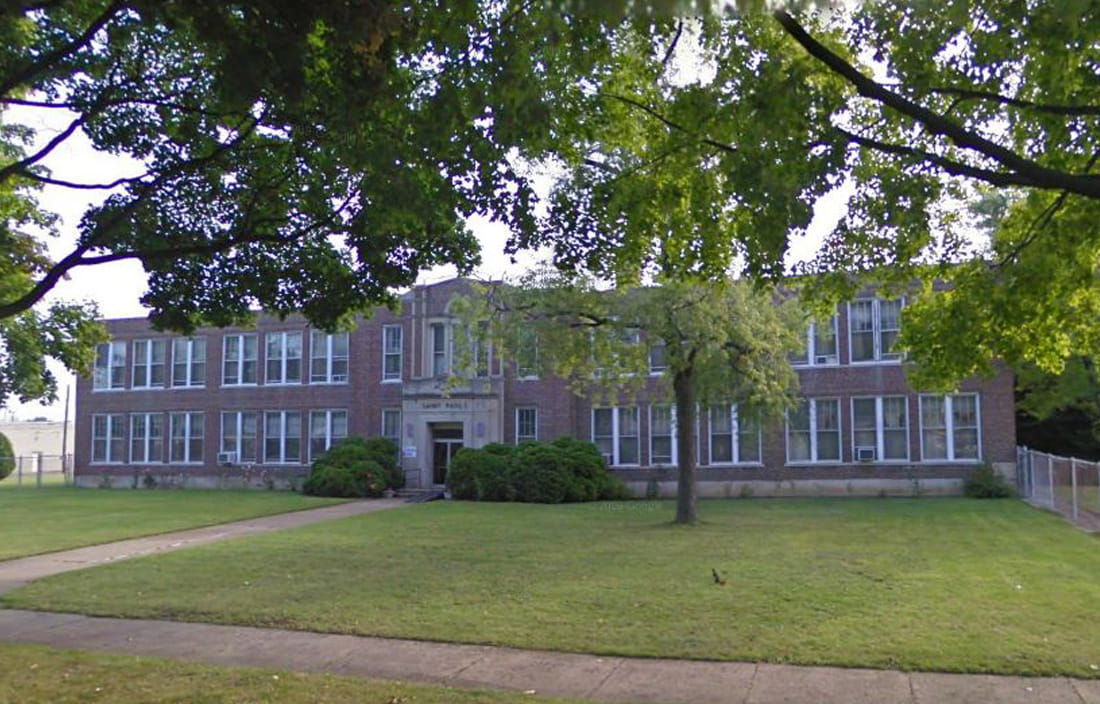 View of Pious Society of St. Paul school building through tree branches.