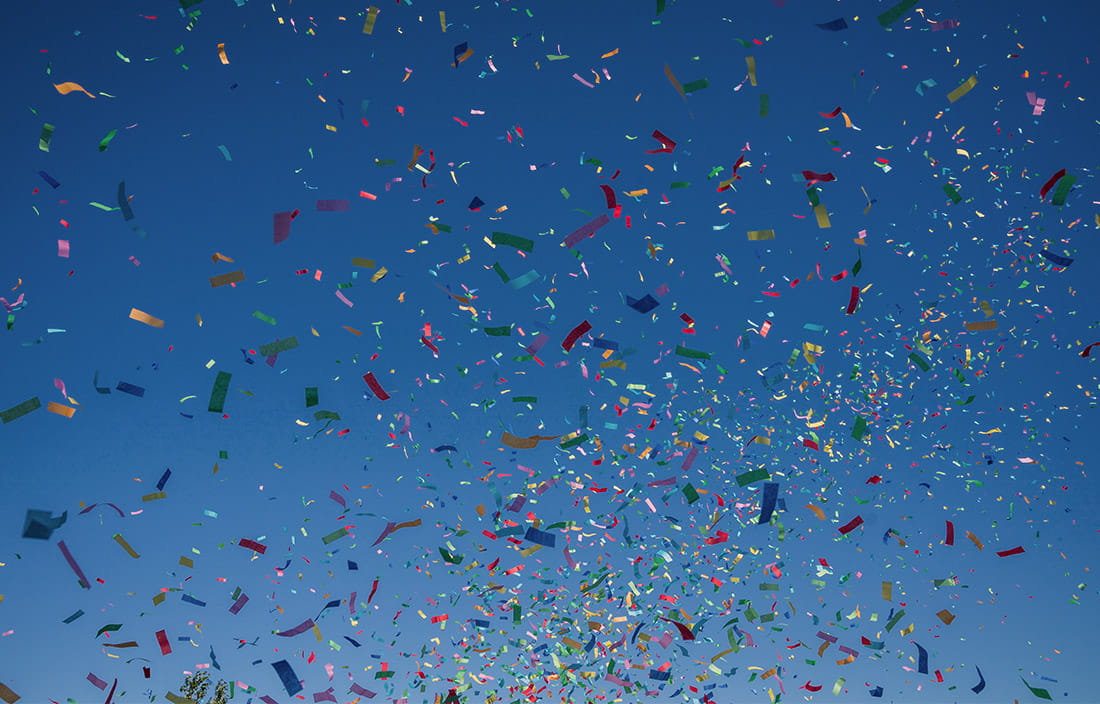 Confetti flying in the air against a blue sky