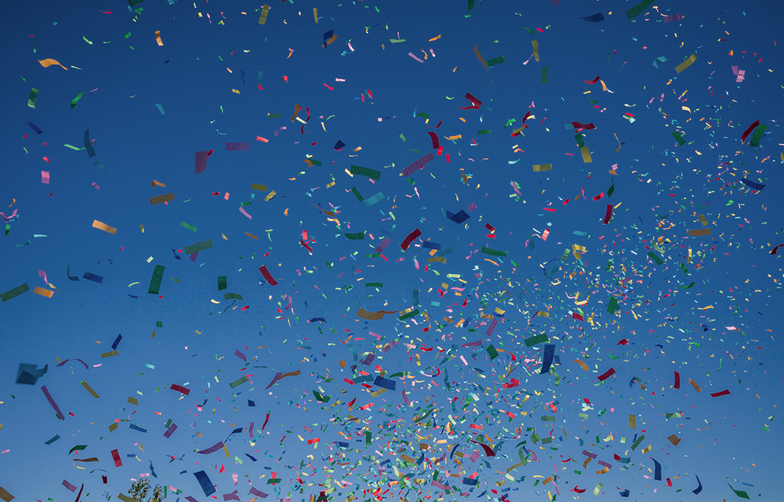 Confetti flying in the air against a blue sky