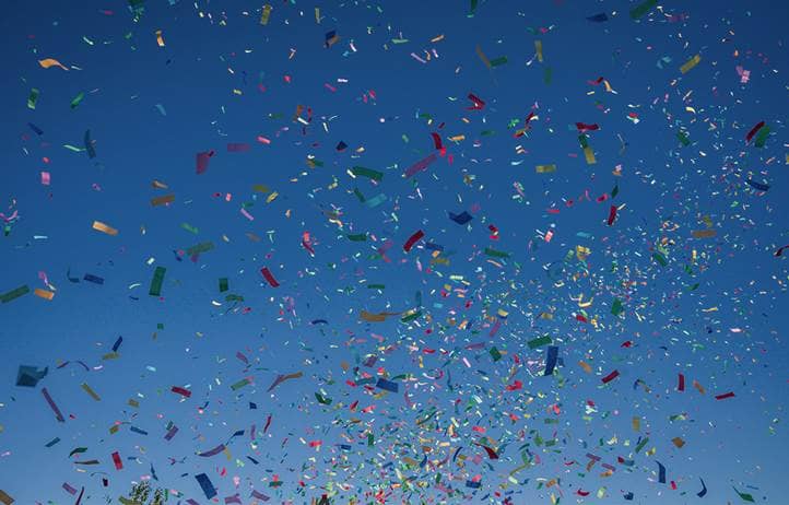 Confetti flying in the air against a blue sky
