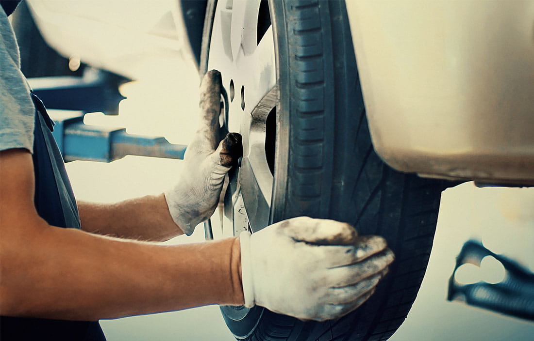 man changing aluminum tire on car