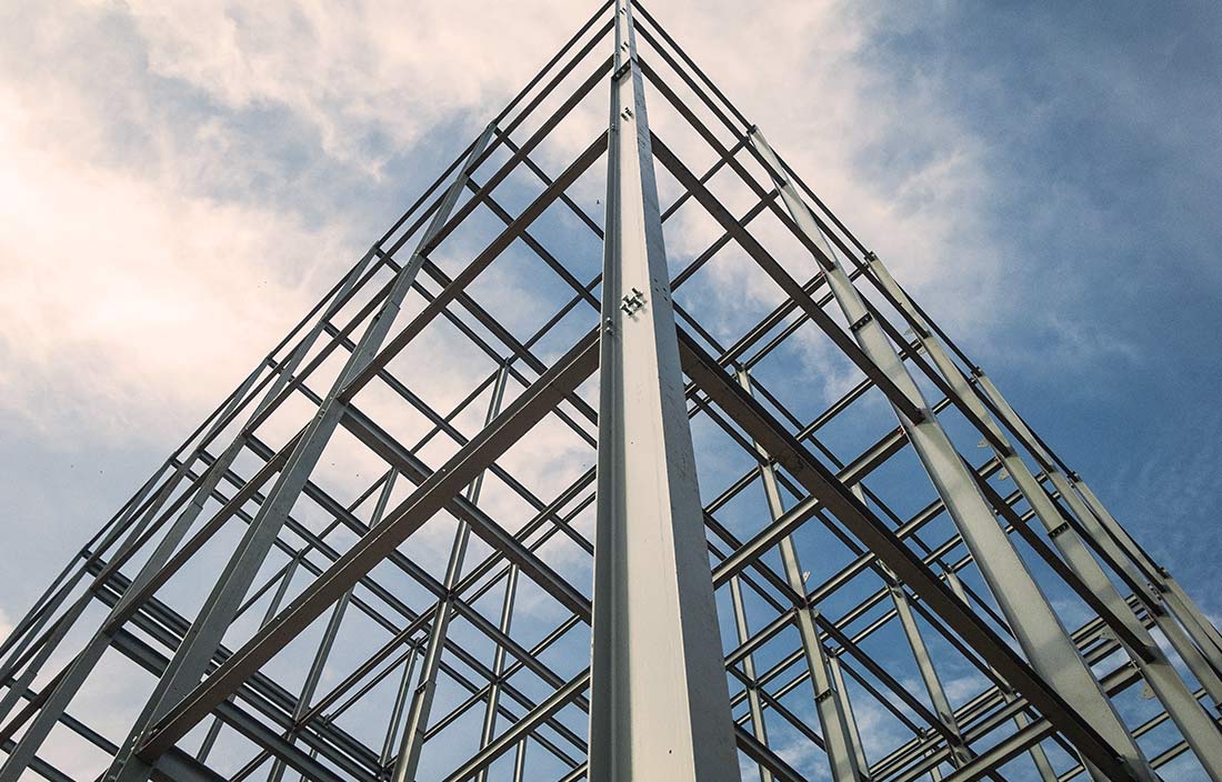 Industrial real estate building structure made out of steel beams against a blue sky