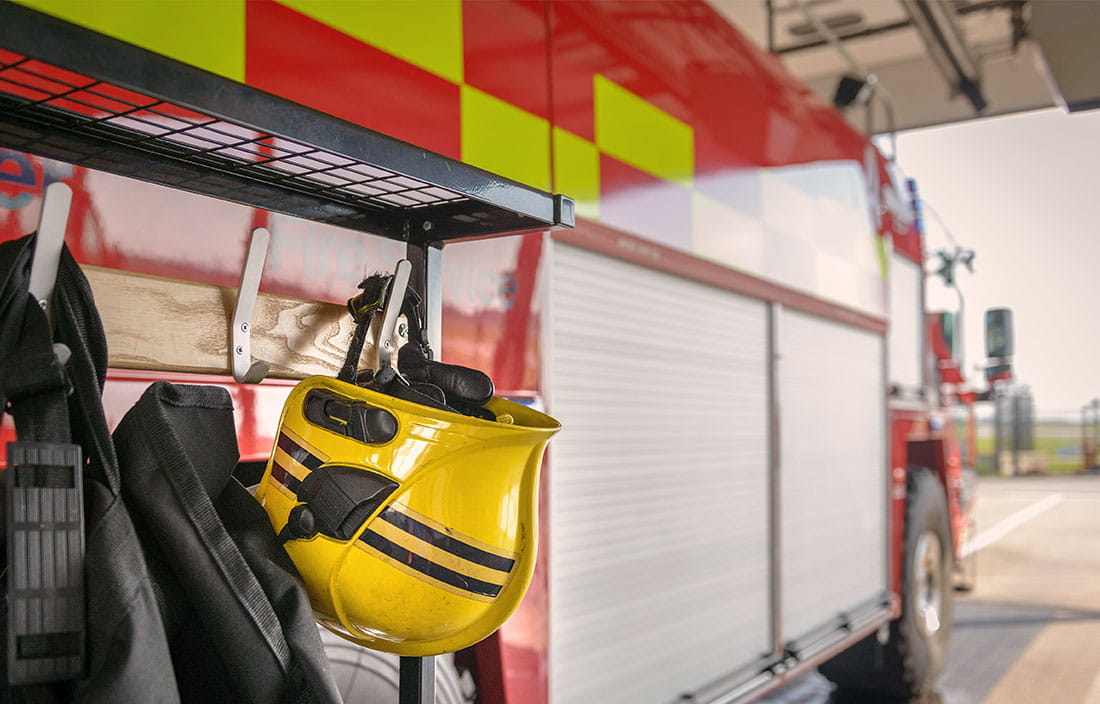 Fireman's helmet hanging by fire engine in fire station