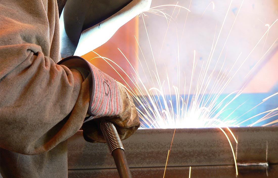 Image of welder welding a steel beam