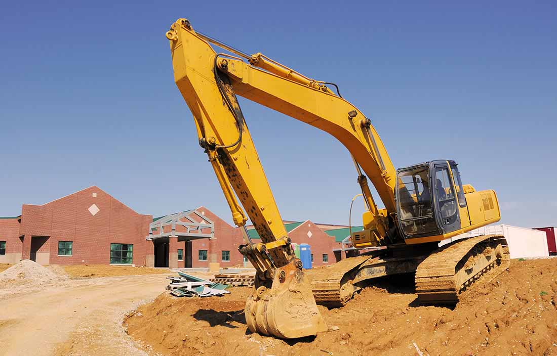 Construction machinery in front of a K-12 school as part of a school bond program construction project