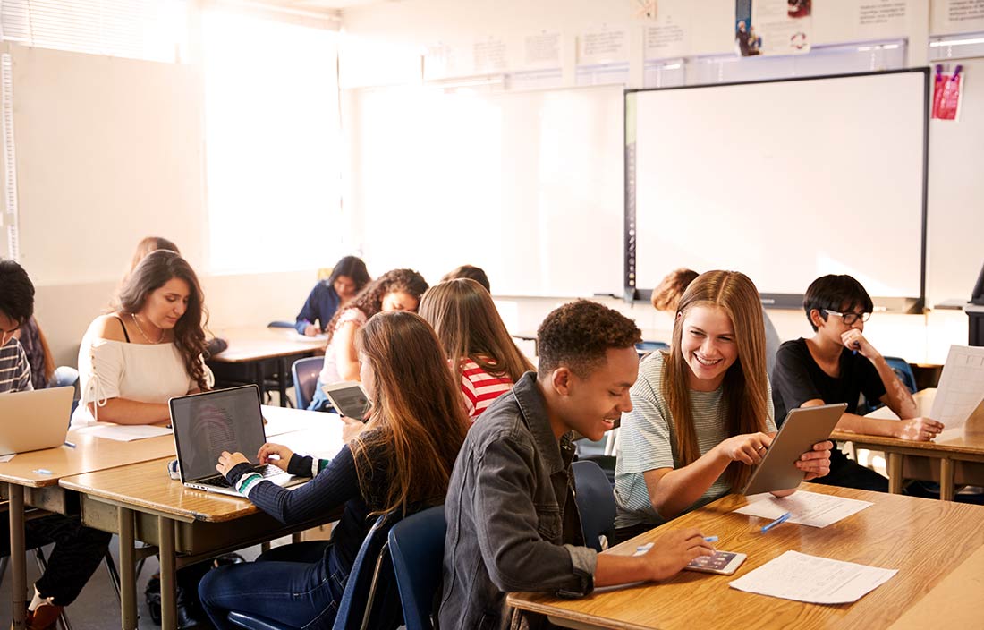 Teenagers in a modern high school classroom working on homework