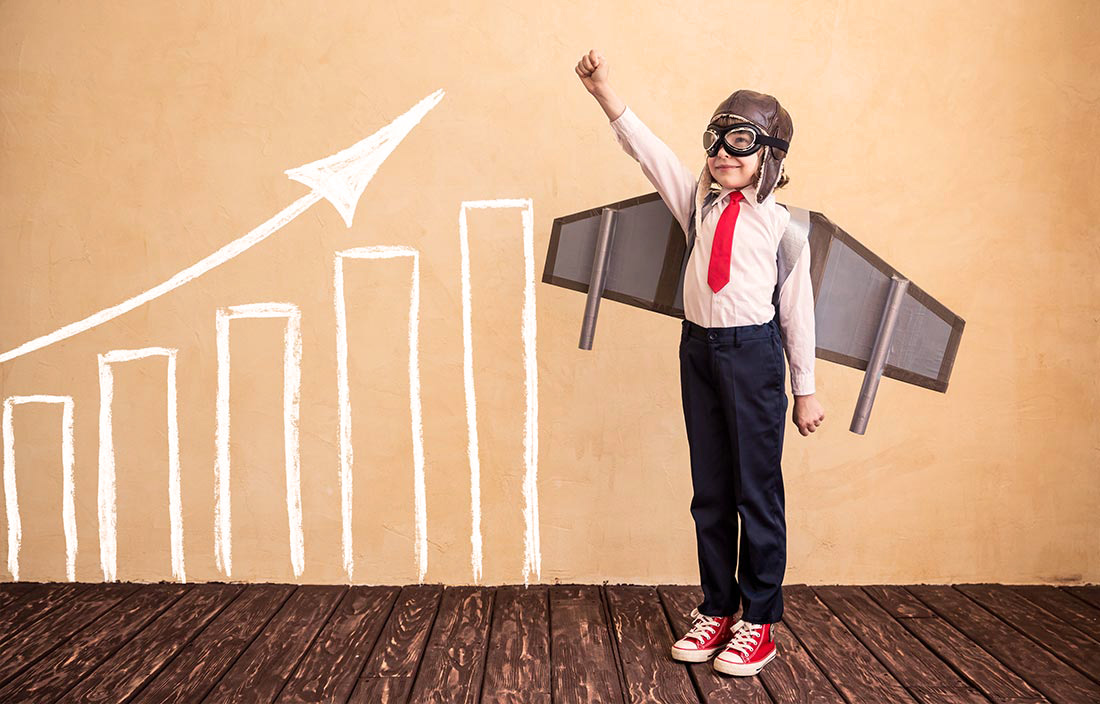 A child dressed as an aviator with homemade wings next to a bar graph indictated an increase