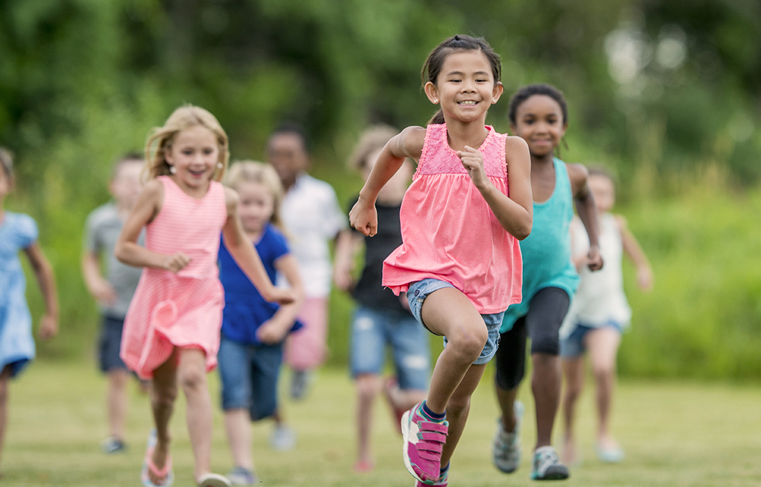 Image of elementary school kids running on the grass