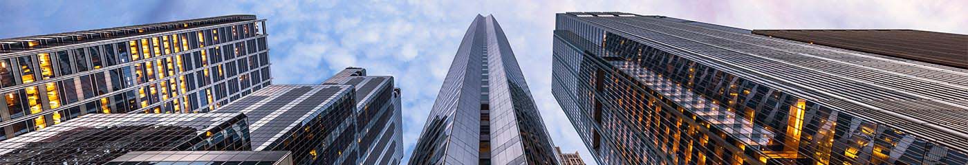Close-up view looking up at skyscrapers in a city.