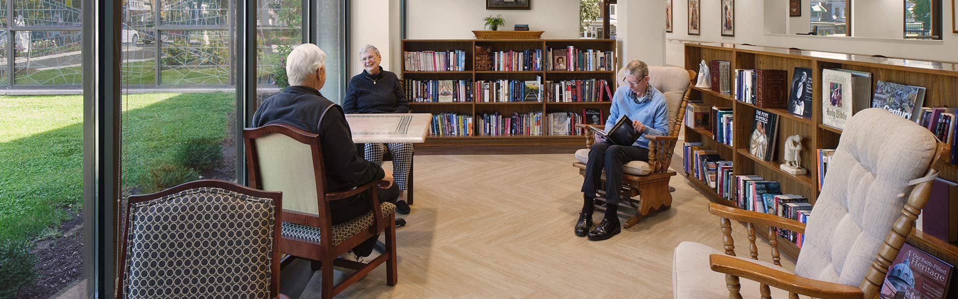 Little Sisters of the Poor Holy Family Home renovated nursing home reading area with bookshelves and chairs