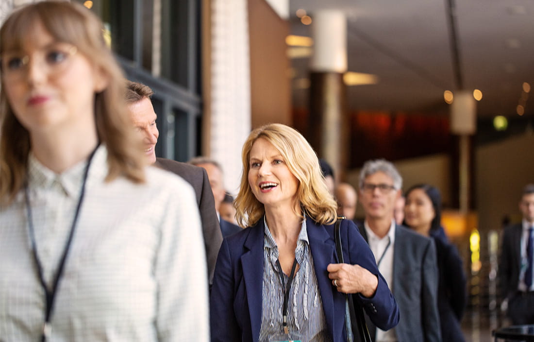Business professionals or executives walking in corridor during a break in conference.