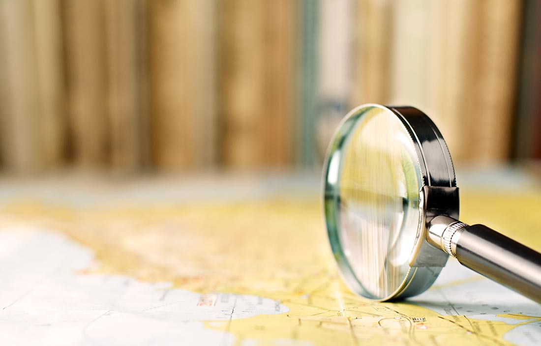 Magnifying glass tipped on its side on top of a map on a table
