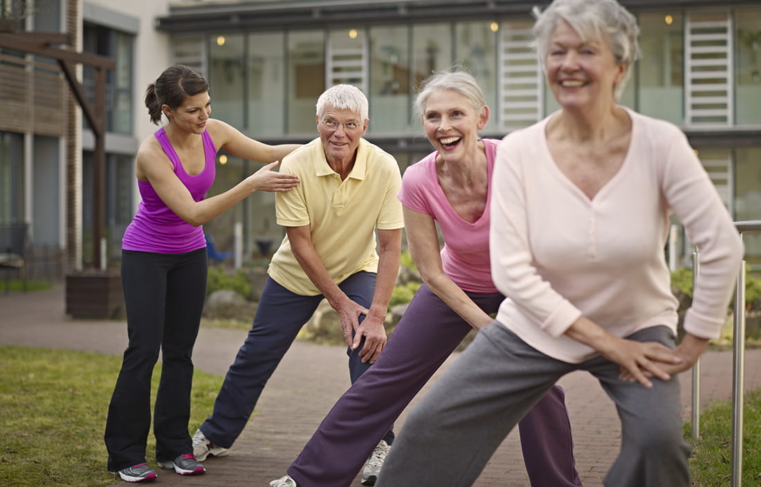 Senior living community staff engaged in a meaningful wellness and fitness activity with a group of seniors