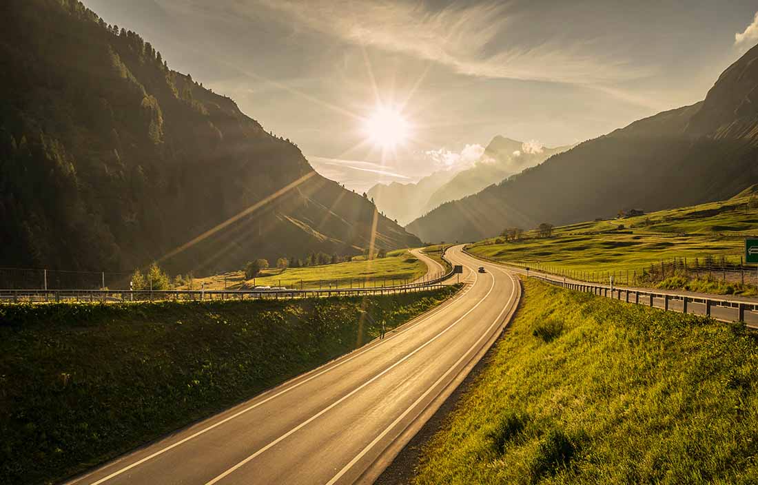 Road leading into the mountains and sun