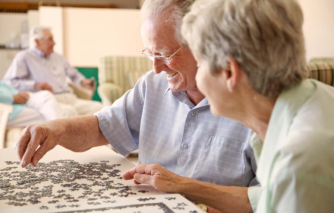 Photo of a couple putting together a puzzle at a senior living community