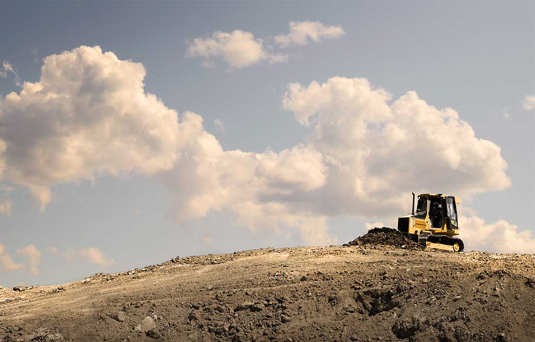 Bulldozer working on a hill of dirt for a new development