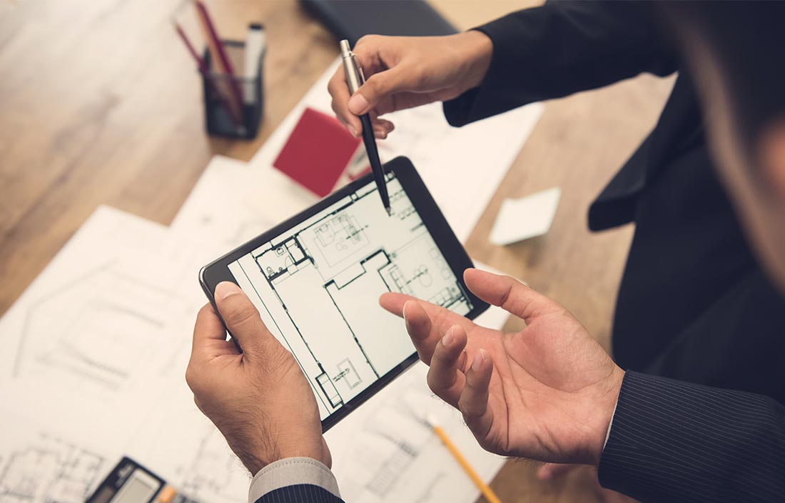 Real estate development consultant with client and senior living architect team checking a housing model and its blueprints digitally using a tablet