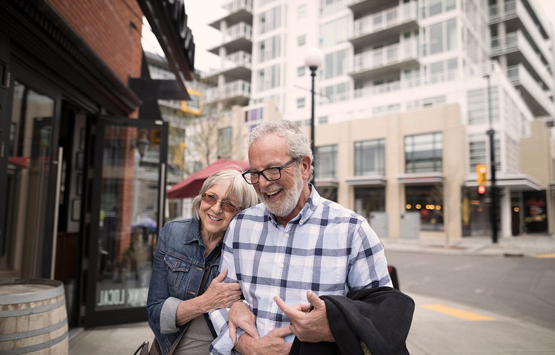 Senior couple walking and laughing in a big city