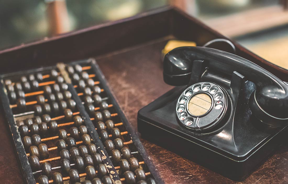 Abacus and old-style telephone represent a change in how people do things over time