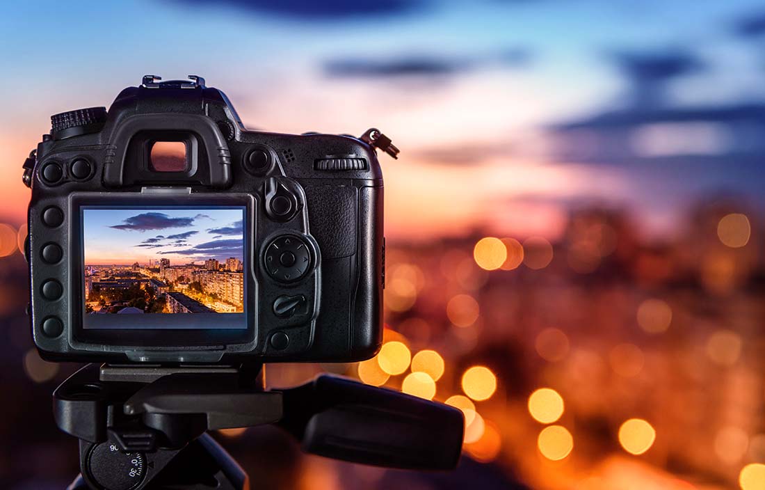 Close up of a camera taking a picture of a city from far away