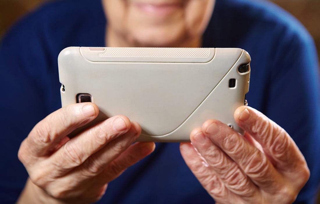 Image of older lady holding a smart phone to show how technology is changing senior living