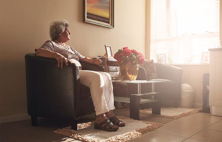 Older women in room looking out a window