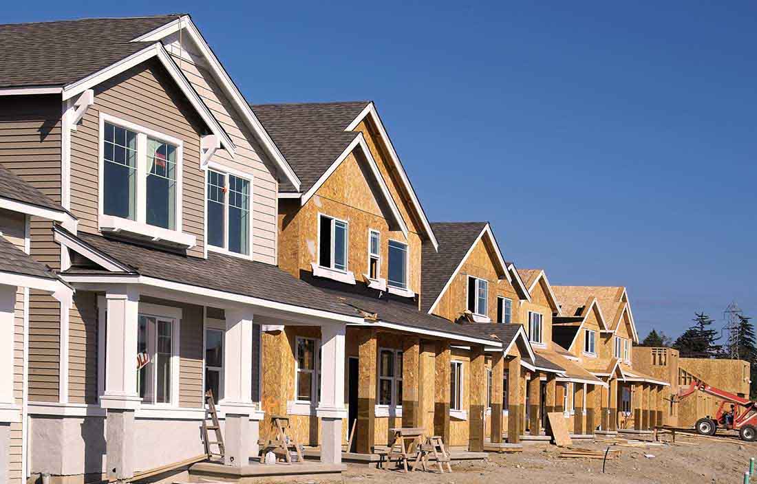 Senior living development of repositioned homes, with one home complete and sold and the others along the street under construction