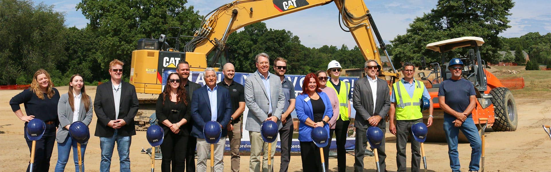 People smiling at the Waterford Township community center groundbreaking ceremony.