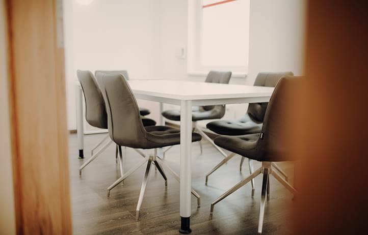 Partial view into an empty conference room, door blocking part of the entrance