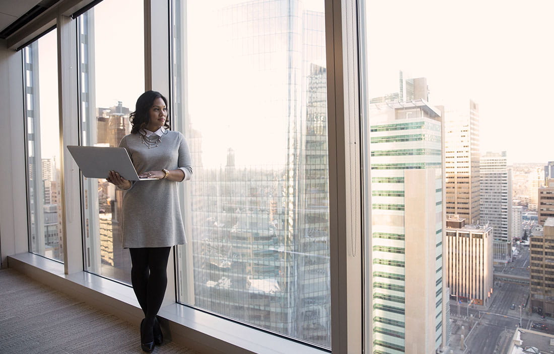 High-class woman with a laptop overlooks a city