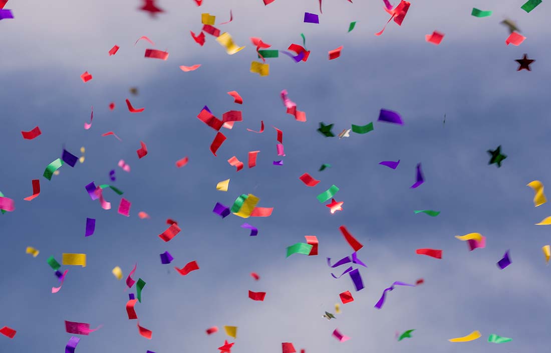 Colorful confetti against a blue sky