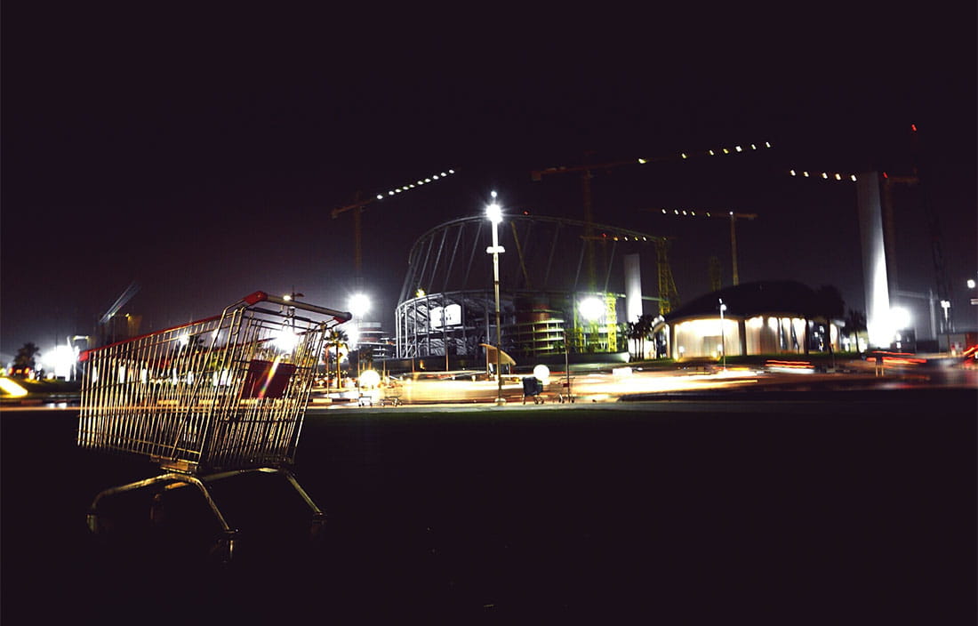 exterior of shopping center at night with cart in the foreground