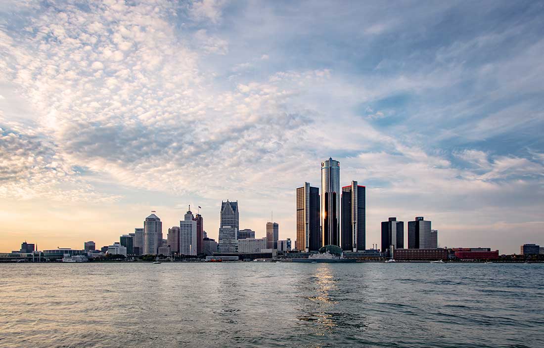 Detroit's skyline - Daytime - across the Detroit River - stock photo This picture of Detroit shows the entire downtown skyline as seen from Windsor. The Detroit River is in the foreground, and a blue sky with scattered clouds make the backdrop for the city. A slight reflection of the city is seen in the ripples of the river.