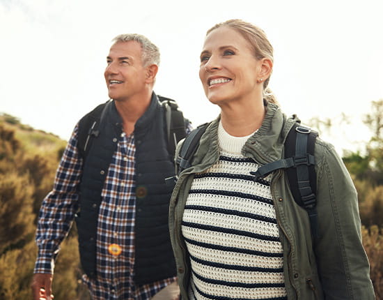 Middle aged couple hiking during the day.