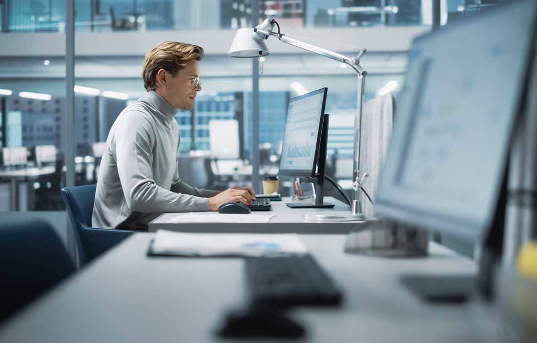 Man looking at a computer screen in an office.
