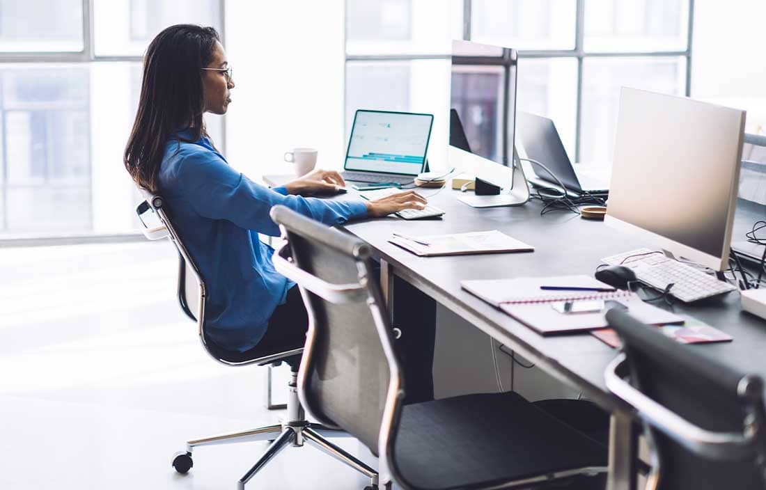 Women in an office at a desk looking at a computer.