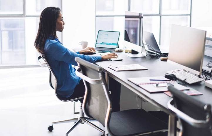 Women in an office at a desk looking at a computer.