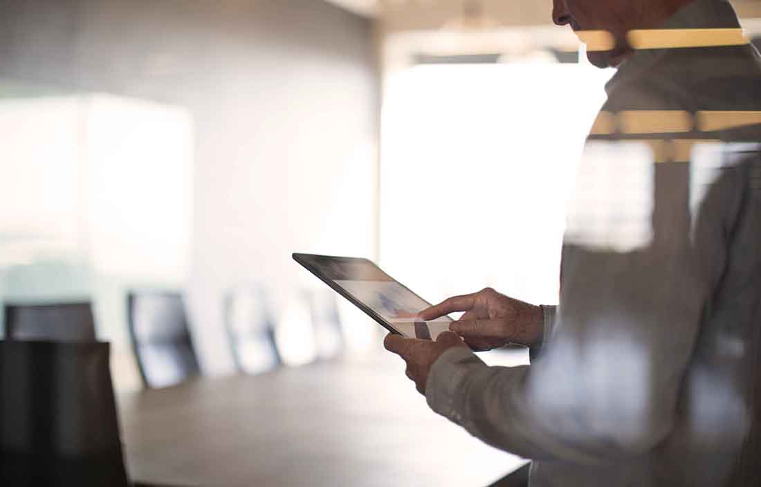 Person holding a tablet looking at GDP data