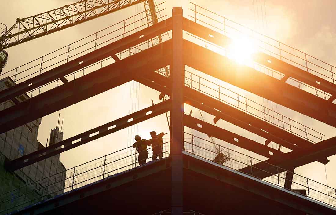 Two people standing on bridge at manufacturing facility