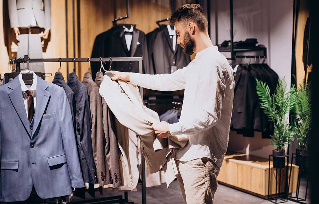 Man at a store looking at a suit.