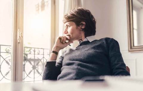 Woman looking out window thinking