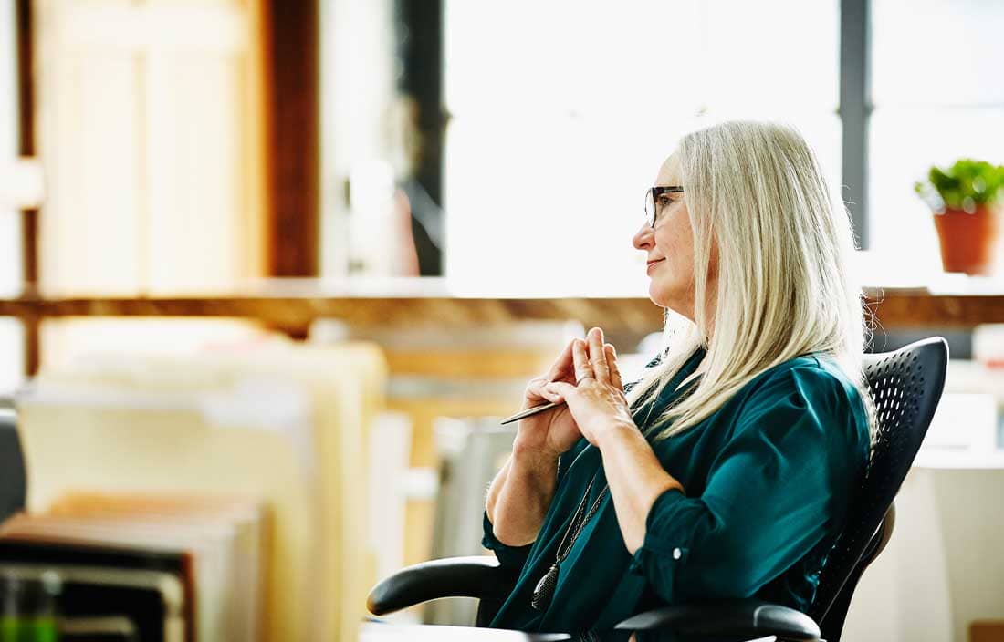 Woman sitting in a chair and looking off to the side.