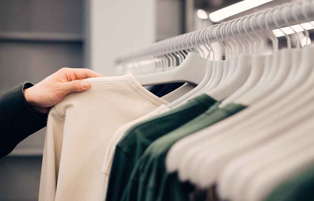 Customer pulling out a shirt from the clothing rack