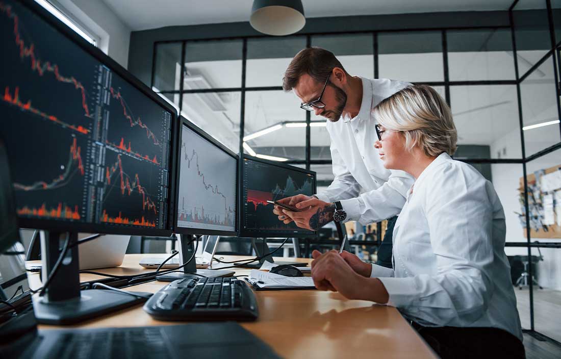Two people sitting at a desk looking at hard and soft data
